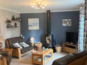 a living room with a couch and a tv at Lighthouse Cottage Cullen in Cullen