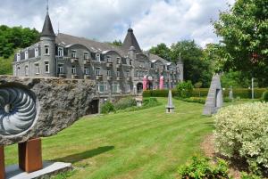 a large building with a garden in front of it at Floreal La Roche-en-Ardenne in La-Roche-en-Ardenne