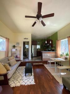 a living room with a couch and a ceiling fan at Blissful Acres hilltop cottage in Grass Valley