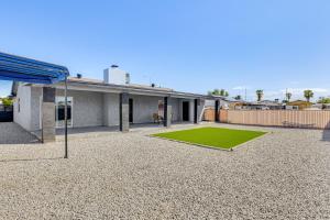 a house with a green lawn in front of it at 3 Mi to Desert Diamond Arena Peoria Home with Yard! in Shamrock Mobile Home Park