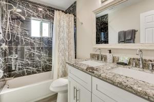 a bathroom with two sinks and a shower and a toilet at 3 Mi to Desert Diamond Arena Peoria Home with Yard! in Shamrock Mobile Home Park +22 photos