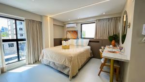 a hotel room with a bed and a table and window at Áurea Bauten Cabo Branco Genius Flats in João Pessoa +22 photos