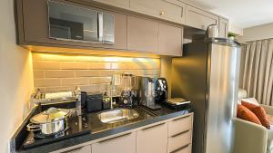 - une cuisine avec un comptoir et une cafetière dans l'établissement Bauten Áurea Cabo Branco Genius Flats, à João Pessoa