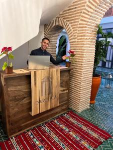 a man sitting at a desk with a laptop at Riad Darchica in Marrakech +102 photos