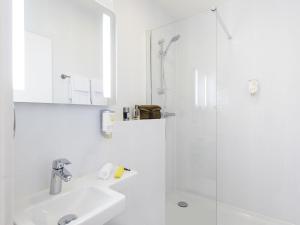 a white bathroom with a sink and a shower at Résidence Studio Genève Centre in Geneva