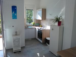a kitchen with white cabinets and a refrigerator at Apartment Julie 4 in Rijeka