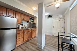 een keuken met houten kasten en een roestvrijstalen koelkast bij Pirates Cove Condo Unit #401 in Halifax Estates