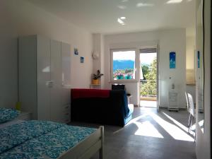 a bedroom with a bed and a couch and a window at Apartment Julie 4 in Rijeka