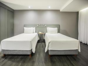ブラジリアにあるGrand Mercure Brasilia Eixo Monumentalの部屋に並んで置かれた2つのベッド