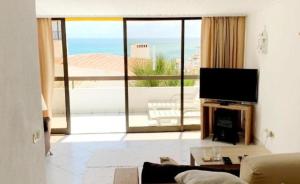 Μια τηλεόραση ή/και κέντρο ψυχαγωγίας στο Ocean view Cerro Branco with pool