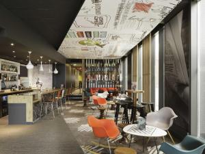 a restaurant with chairs and tables and a bar at ibis London Excel-Docklands in London +106 photos