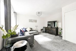 a living room with a couch and a television at Modern 3-Bed Maisonette - Epping High Street - Parking - LMV Property in Epping