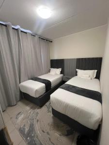 una camera d'albergo con due letti e una finestra di AmeAnele Homes a Gaborone