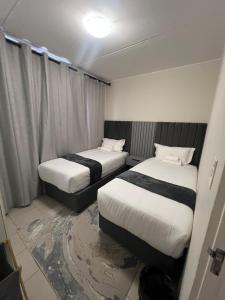 due letti in una stanza d'albergo con il pavimento in disordine di AmeAnele Homes a Gaborone