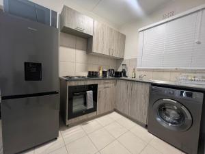 una cucina con lavatrice e lavatrice di AmeAnele Homes a Gaborone