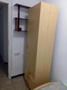 a wooden cabinet in a bedroom next to a refrigerator at ghania in Castellón de la Plana