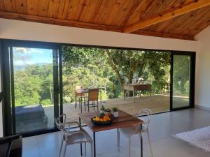a dining room with a table and chairs and a piano at Chalé Alto padrão in Brazópolis