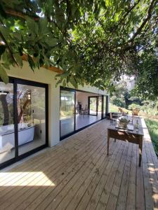 a wooden deck with a table and a house at Chalé Alto padrão in Brazópolis