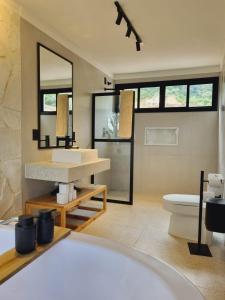 a bathroom with a white sink and a toilet at Chalé Alto padrão in Brazópolis