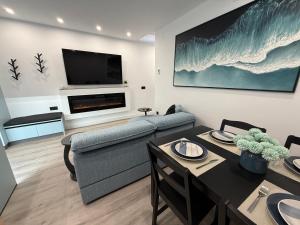 a living room with a couch and a tv at La Casita del Mar in Combarro