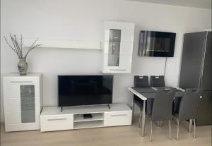 a living room with a tv and a table and chairs at Amazing view-18th floor-2 bedrooms flat - free parking in Trnávka