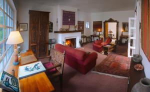 a living room with red furniture and a fireplace at Hacienda Cusin in Otavalo