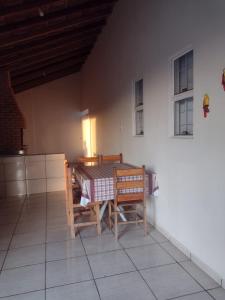 a dining room with a table and chairs in a room at Casa de temporada lus delicatte in Olímpia