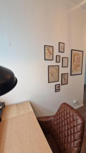 a chair sitting next to a table with pictures on a wall at Altstadt Apartment beim Schlossgarten in Schwerin