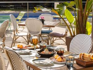 a table with food and drinks on a patio at Novotel Barcelona Cornellà in Cornellà de Llobregat