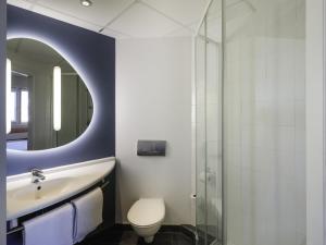 Un baño con lavabo, inodoro y espejo. en Ibis Budget Málaga Aeropuerto Avenida de Velazquez, en Málaga 23 fotos más