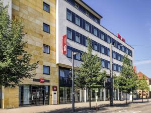 un edificio en una calle con árboles delante en ibis Heilbronn City, en Heilbronn