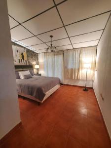 1 dormitorio con 1 cama y 1 lámpara en el suelo de baldosa en Gran Bonanza Hotel, en Alegría
