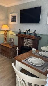 a living room with a table and a tv at Escape to the Chalet in Withernsea
