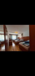 a bedroom with two beds and a living room at Motel Mijošek in Rogaška Slatina