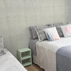 a bedroom with two beds and a green end table at SEO Apê no Centro de Serra Negra -em frente a Rodoviária in Serra Negra +16 photos