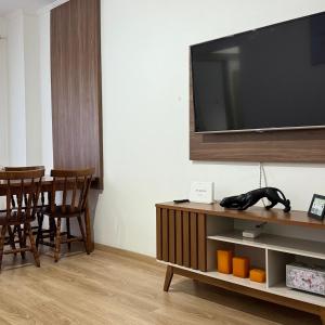 a living room with a tv and a table with chairs at Apartamento Completo no Centro Serra N in Serra Negra