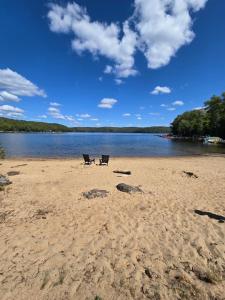 two chairs sitting on a sandy beach next to a lake at The Beaver Den in Haliburton +24 photos