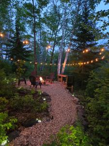 a patio with chairs and a table with lights at The Beaver Den in Haliburton