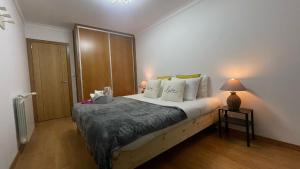 una camera da letto con un letto e una lampada su un tavolo di Apartamento com 1 quarto para casais ou amigos a 20 min de Lisboa a Montijo