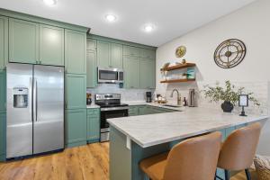 a kitchen with green cabinets and a refrigerator at Baby Birch Banks Guest House on Lake Pend Oreille in Sagle