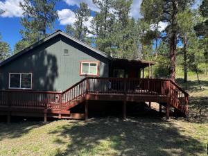 a home with a large deck and a house at Dear Love Cabin in Ruidoso