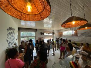 a crowd of people standing in a room with a restaurant at Ragamuffin Hostel in Kingston