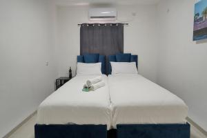 a large white bed with blue headboard in a room at לויקיישן in Tiberias
