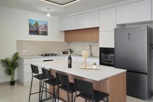 a kitchen with a large island with black bar stools at לויקיישן in Tiberias +289 photos
