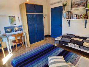 a bedroom with blue doors and a bed and a desk at CHAMBRES chez nous Sorties A62 6 ou 6 1 in Saint-Laurent
