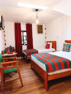 クスコにあるEcoterra Pampa del Castilloのベッドルーム1室(ベッド2台、椅子、テーブル付)