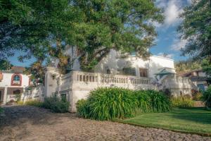 a white house with a white fence and trees at Hacienda Cusin in Otavalo +30 photos