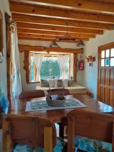 Un comedor con una mesa y un gran ventanal. en Tierras del Sur, en Villa La Angostura
