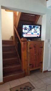 sala de estar con escalera y TV de pantalla plana en Tierras del Sur, en Villa La Angostura