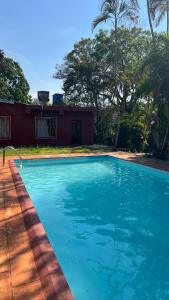una grande piscina blu davanti a una casa di Mango Home Iguazú a Puerto Iguazú